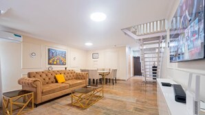 Una sala de estar moderna con un sofá, una mesa de centro y un televisor sobre un mueble.