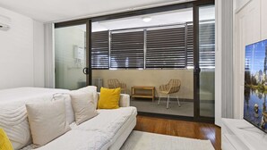 Ein modernes Schlafzimmer mit einem großen Bett, einer Couch und einem Fernseher.