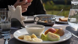 Una mesa de comedor con un plato de comida, un vaso de agua y una jarra.