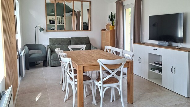 A modern kitchen with a dining area, a large mirror, and a television. - Logis La Dunette Quend 3* House with Garden & Spa (Quend)