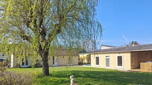 A residential building with a garden, a patio area, and a small outdoor seating space. - Logis La Dunette Quend 3* House with Garden & Spa (Quend)