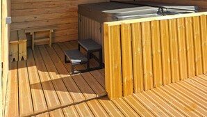 A wooden deck with a hot tub, a bench, and a small table. - Logis La Dunette Quend 3* House with Garden & Spa (Quend)