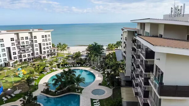 A resort with a large pool, palm trees, and a view of the ocean. - Ventanas Ocean View -V3-8A- 2 bed, 2 bath (Punta Chame)