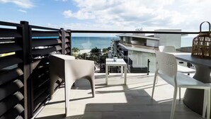 A balcony with a view of the ocean, a table, chairs, and a wicker lantern. - Ventanas Ocean View -V3-8A- 2 bed, 2 bath (Punta Chame)