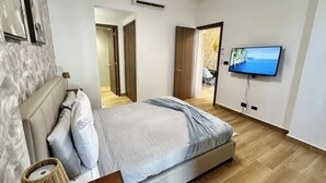 Ein Schlafzimmer mit einem Bett, einem Fernseher und einem Korbwäscheschrank.