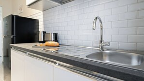 A modern kitchen with a stainless steel sink, a toaster, and a loaf of bread on the counter. - Italianway Easy - Leoncavallo 45 (Milan)