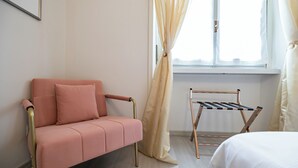 A room with a pink sofa, a metal drying rack, and a bed. - Italianway Easy - Leoncavallo 45 (Milan)