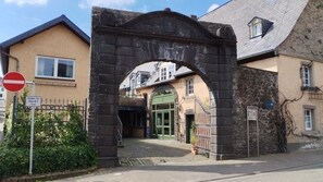 Un arc en pierre mène à un bâtiment doté d’une porte verte, d’un panneau indiquant l’interdiction d’accès et d’un autre panneau indiquant : « L’accès est autorisé jusqu’au numéro 2 ».