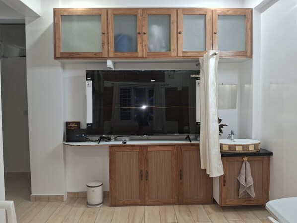 Une cuisine avec des meubles en bois, un plan de travail noir et un évier.