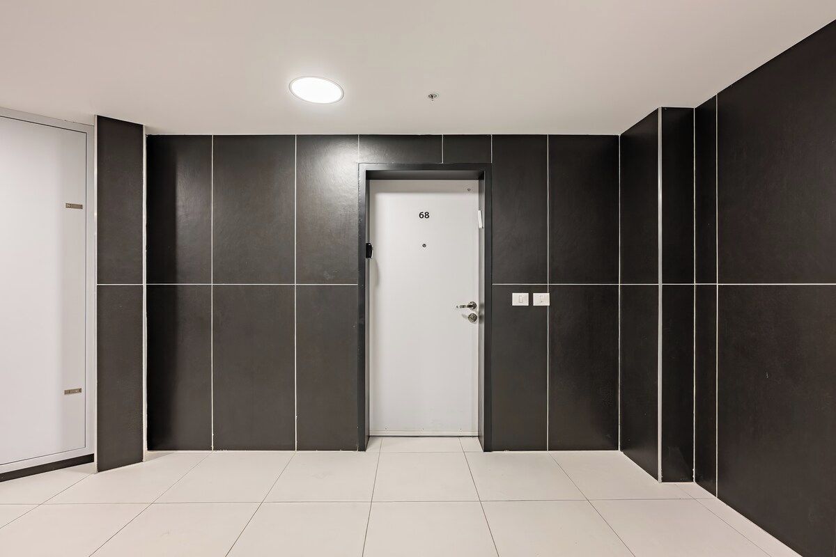 Een moderne lift met een deur waarop '68' staat in een hotelhal.