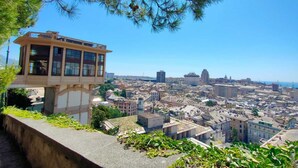 Ein erhöhter Aussichtspunkt mit Blick auf eine Stadtlandschaft, ein Gebäude mit großen Fenstern und einem Balkon.