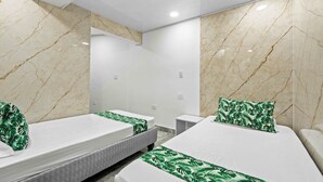 Habitación de hotel con dos camas, paredes de mármol y diseño moderno.