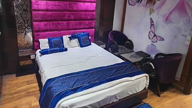 A bedroom with a bed, a desk, a chair, and a wall with a butterfly mural.