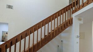 Eine Holztreppe mit weißer Wand und hellem Boden.