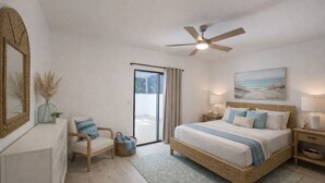 Ein Schlafzimmer mit Bett, Sessel, Nachttisch, Lampe, Deckenventilator, Fenster und einem Bild an der Wand.
