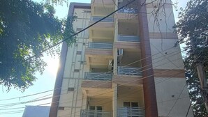 A multi-story building with a sign reading "HILL NEST STUDIO APARTMENT." - IP Hill Nest By Qotel Sahastradhara (Dehradun)