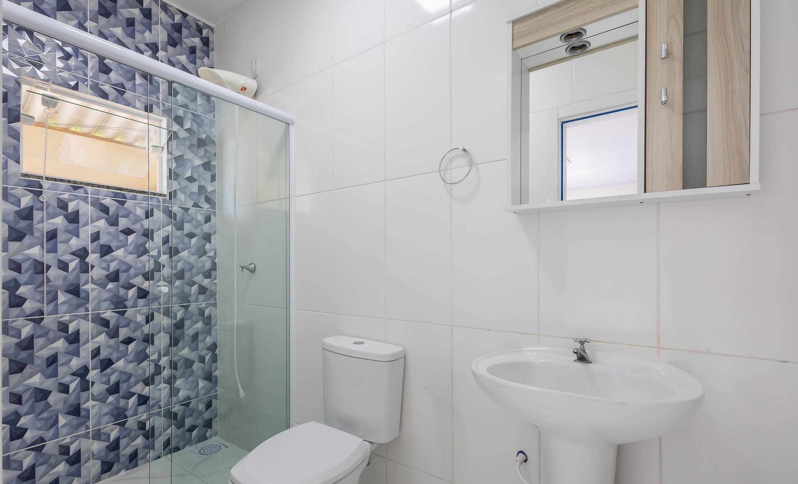 Ein Badezimmer mit Dusche, Toilette und Waschbecken.