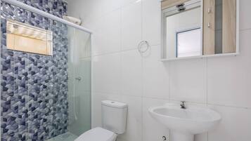 Ein Badezimmer mit Dusche, Toilette und Waschbecken.
