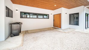 Un interior moderno con techo de madera, un ventanal grande y una puerta.