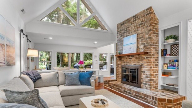Una sala de estar moderna con chimenea, un conjunto de sofás y una estantería.