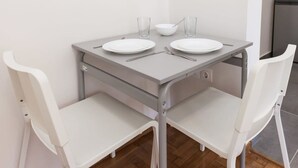 A small, modern dining area with a grey table and two white chairs. - Core Stay Marousi Fully Renovated Studio (Marousi)