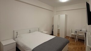 A bedroom with a bed, bedside tables, a desk, a chair, and a mirror. - Core Stay Marousi Fully Renovated Studio (Marousi)