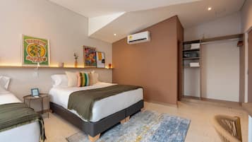 A bedroom with two beds, a large window, an air conditioning unit, and a walk-in closet.