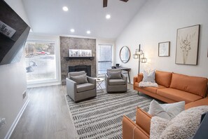 A modern living room with a fireplace, two armchairs, a sofa, and a patterned rug. - Sandy Springs Spacious 3 Bedroom, 2 Bath | 2 King Beds | Central Location (Atlanta)