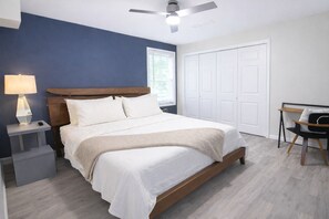 A bedroom with a bed, bedside table, lamp, chair, and a ceiling fan. - Sandy Springs Spacious 3 Bedroom, 2 Bath | 2 King Beds | Central Location (Atlanta)