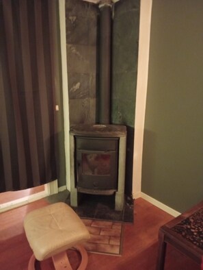 A corner room with a stone fireplace, a wooden bench, and a small table. - B&BG7 B&BG7 (Vaggeryd)