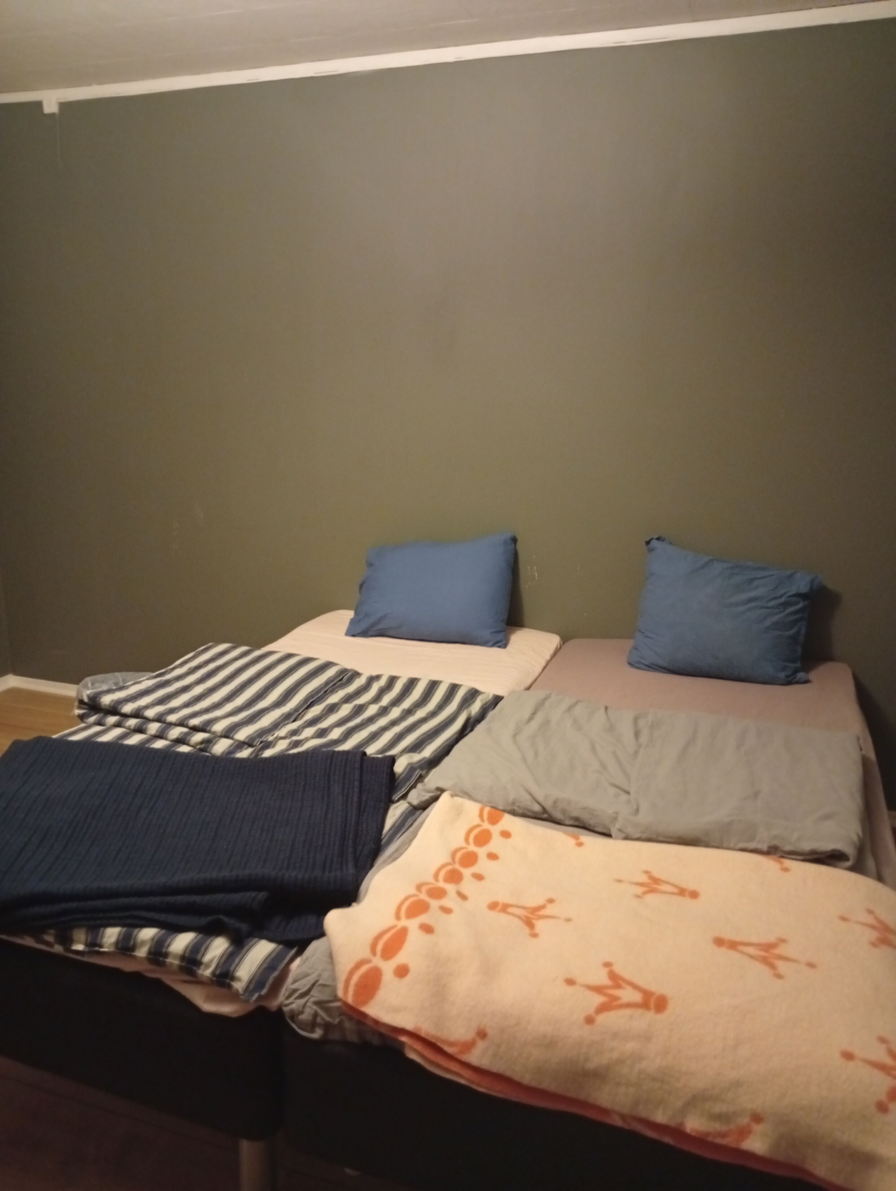 Un lit avec une literie à rayures et unie, deux oreillers et une couverture à motifs.