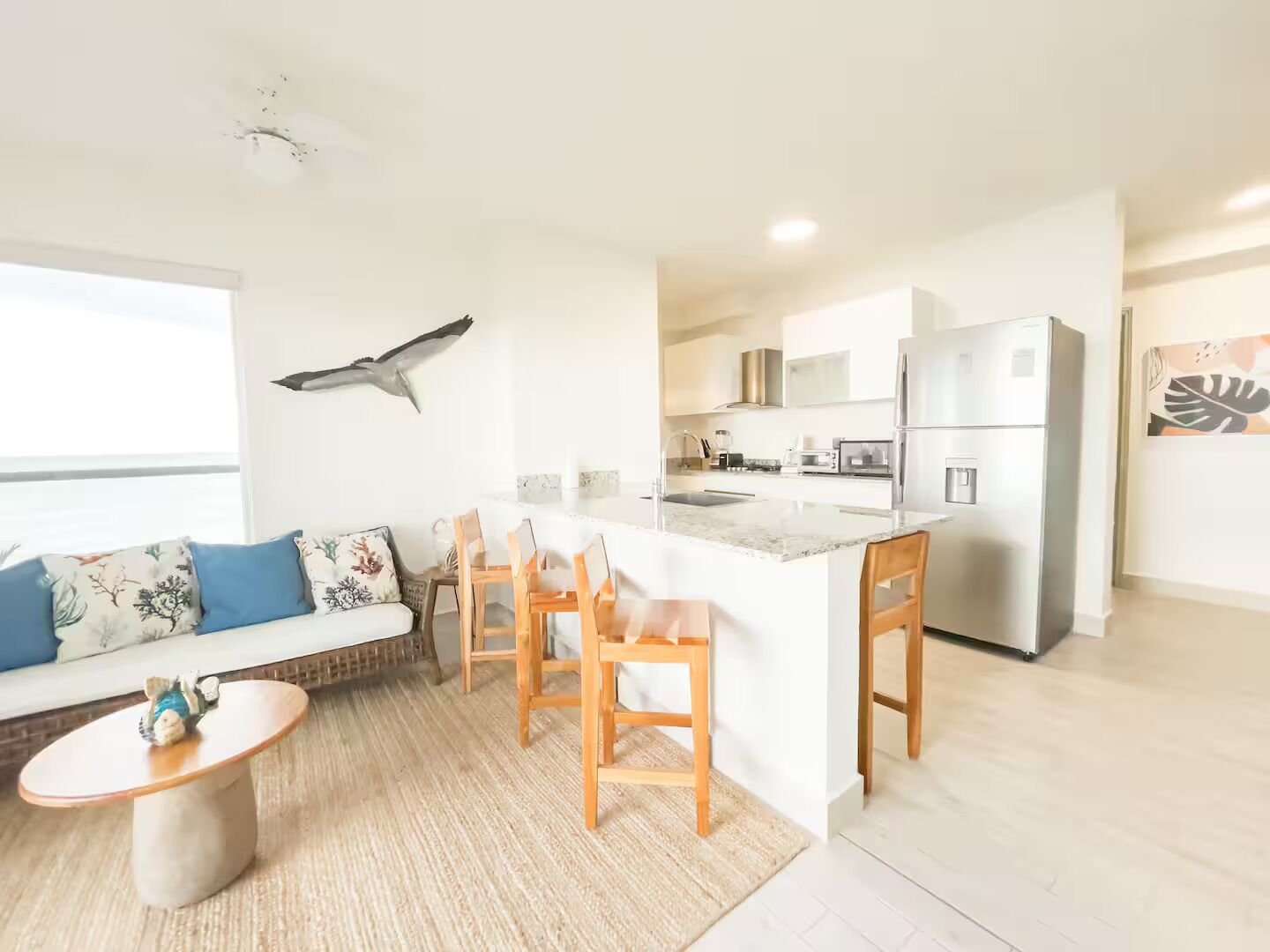 A modern kitchen with a central island, wooden chairs, and a dining table.