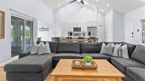 A modern living room with a sectional sofa, a wooden coffee table, and a ceiling fan. - Remodeled Center Island Home, Marsh Views, 2 Golf Carts, Stellar Sunsets (Fripp Island)