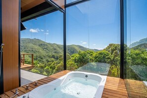 A hot tub on a wooden deck with a view of green hills. - Romantic Cabin Near Florianopolis Vst041 (Anitapolis)