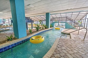 Piscina interna com água cristalina, boias amarelas infláveis e piso ladrilhado.