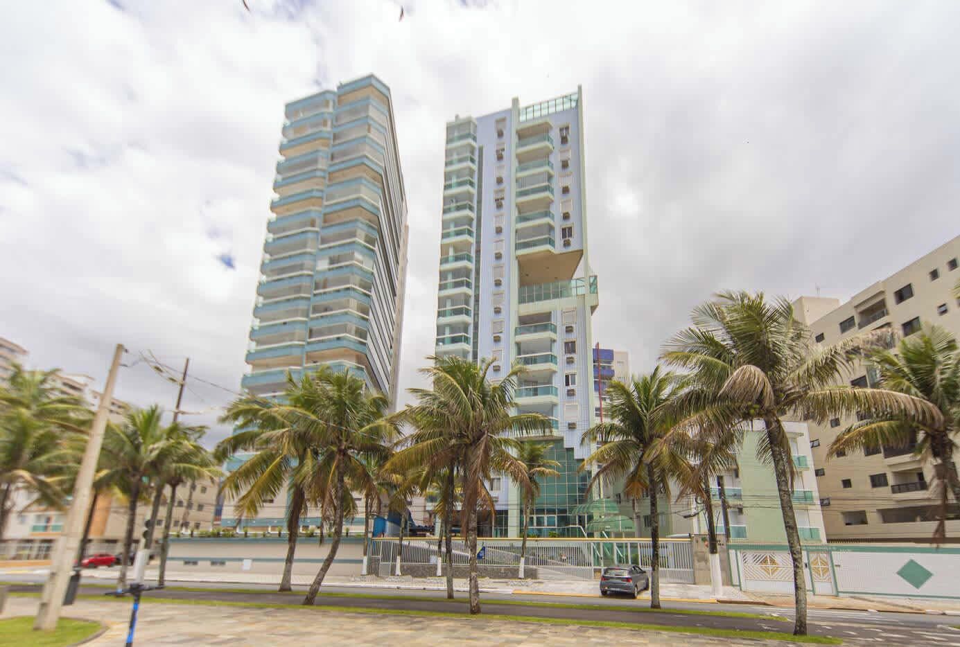 A modern high-rise building with a unique architectural design, featuring multiple balconies and a glass facade.