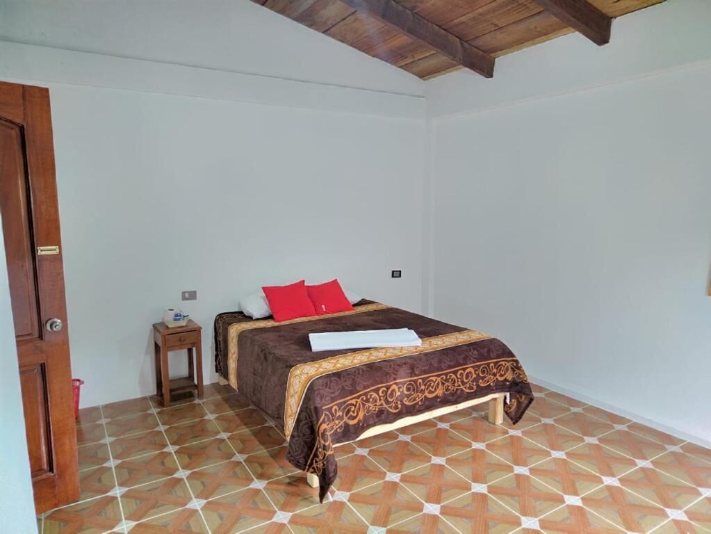 Une chambre à coucher avec un lit, une table de chevet et une porte.