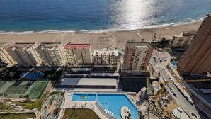 A high-rise hotel with a pool, beach view, and multiple amenities including tennis courts. - SUNSET SAILORS sea & sky apartment (Benidorm)