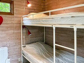 A bunk bed room with wooden walls, a window, and a red lamp. - 6 Person Holiday Home in Lottorp (Löttorp)