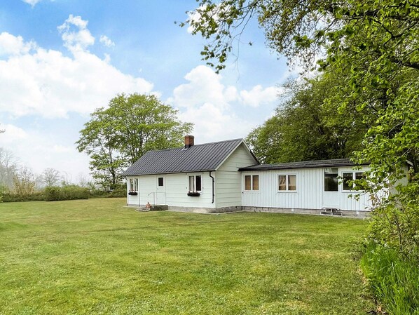 A single-story house with a sloped roof, a chimney, and a front porch with a bench. - 6 Person Holiday Home in Lottorp (Löttorp)