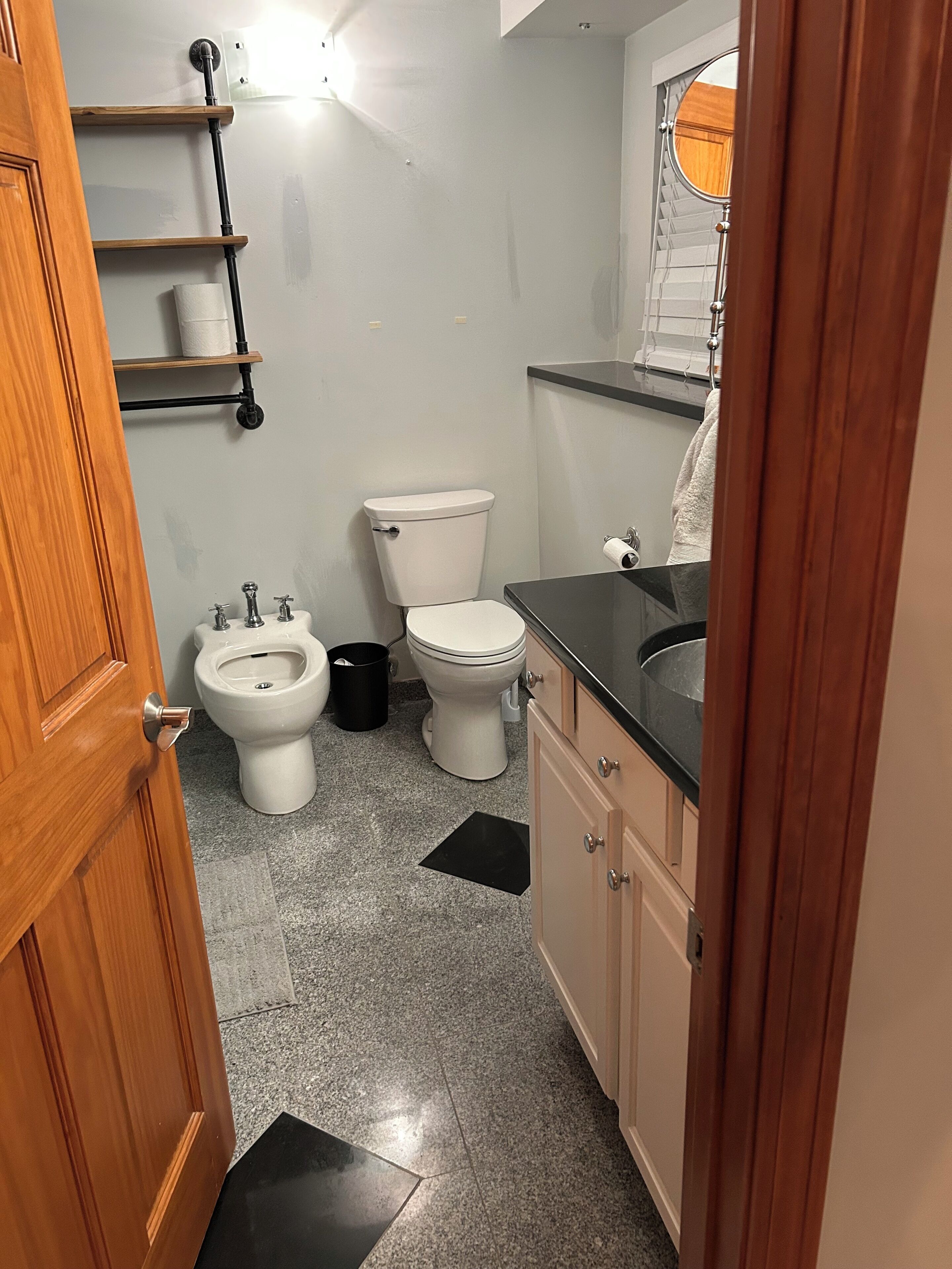 Een kleine badkamer met toilet, wastafel en bidet.