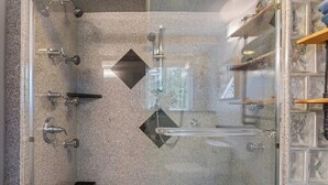 A modern shower with multiple fixtures, a glass enclosure, and a granite countertop. - Private Luxury 2 Bedroom Suite (Framingham)