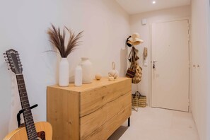 A hallway with a wooden dresser, a guitar, a hat rack, and a door. - Bright, A/C Apartment With sea View - Antibes (Antibes)