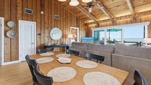 Ein Holzinterieur mit Esstisch, Stühlen, einer Couch und einem Deckenventilator.