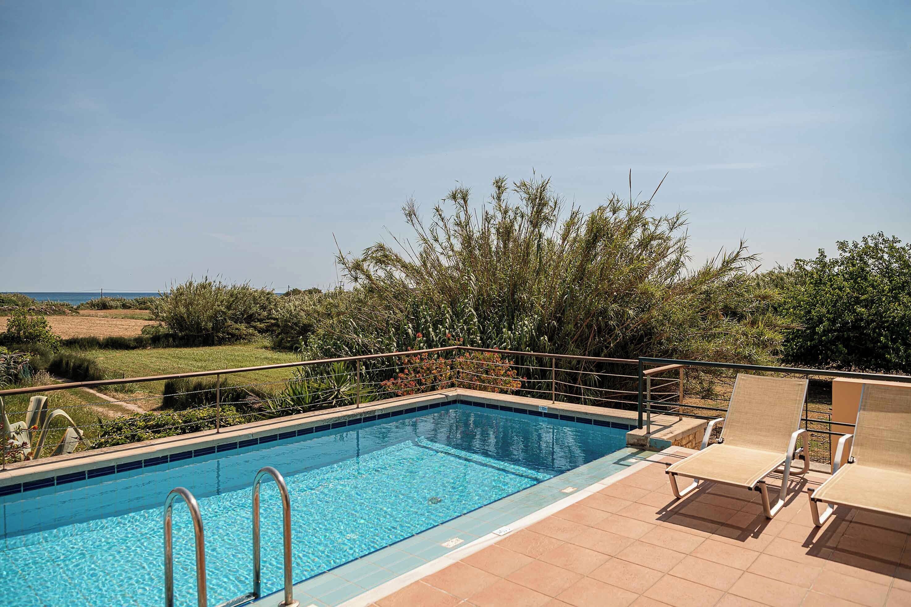 Une piscine avec vue sur la campagne, entourée de verdure et sous un ciel dégagé.