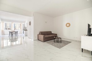 A modern living room with a sofa, a coffee table, and a TV stand. - Posta Suites - 1br/4p - a Ventimiglia (Ventimiglia)