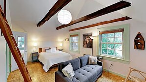A bedroom with a bed, a sofa, a window, and a staircase. - Entire 4-Unit House - Downtown Bar Harbor (Bar Harbor)