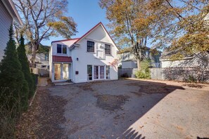 A two-story house with a red roof, a front porch, and a garage. - Sunset Studio in the Heart of Bar Harbor (Bar Harbor)