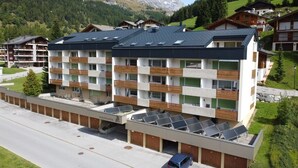 Un hotel moderno de varios pisos con tejado plano, balcones y paneles solares.