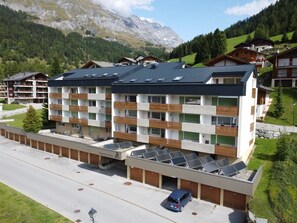 Ein modernes, mehrstöckiges Hotel mit flachem Dach, Balkonen und Solaranlagen.